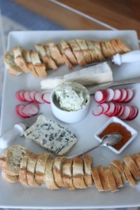Herbed butter (center), sliced radishes and sliced baguettes along with some cheeses