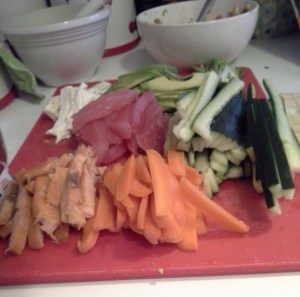 While your rice cooks, get all of your other ingredients prepped and put together for easy rolling. Here we have a bowl of spicy tuna, cream cheese, tuna, avocados, cucumbers, green onions, carrots and smoked salmon.