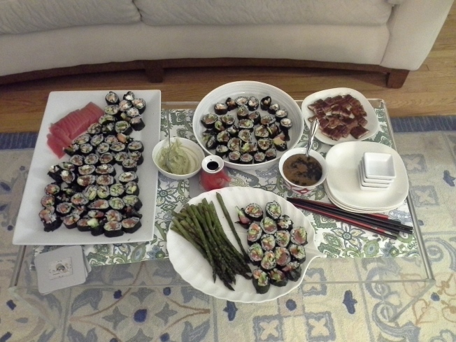 Sushi for 4: tuna, spicy tuna, eel, salmon, cream cheese and veggies all in various rolls, tuna and eel on the side, served with wasabi, eel sauce and roasted asparagus